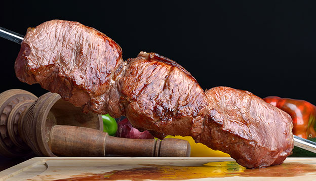 A skewer of beef served at a Brazilian Churrasco A skewer of beef served at a Brazilian Churrasco