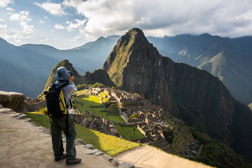 Tourist in front of ancient ruin with mountain in background tourist in front of ancient ruin with mountain in background