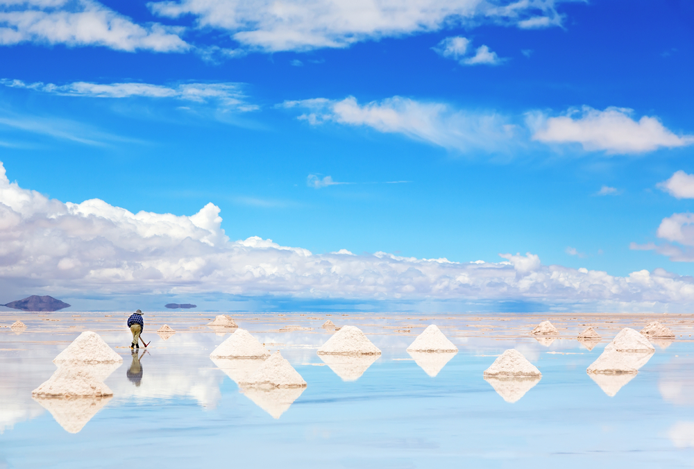 Worker performing harvesting salt on the salt lake Salar de Uyuni. Worker performing harvesting salt on the salt lake Salar de Uyuni.