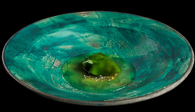 Close up of a dish served on a teal plate set against a black backdrop Close up of a dish served on a teal plate set against a black backdrop