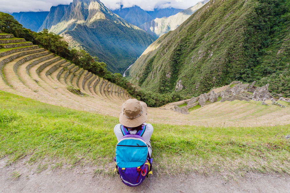 Woman sitting at the Terraced mountainside and buildings at Winay Wayna, The Inca Trail, Machu PIcchu, Cusco, Peru Woman sitting at the Terraced mountainside and buildings at Winay Wayna, The Inca Trail, Machu PIcchu, Cusco, Peru
