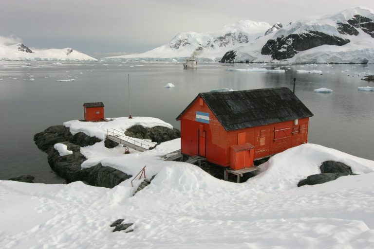 red buiding in the snow on antarctica next to the sea red buiding in the snow on antarctica next to the sea