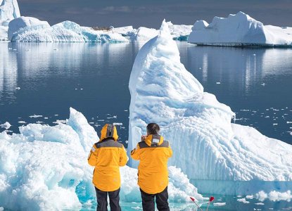 Tourist observe icebergs in calm Antarctic waters) 