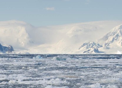 Bay filled with brash ice with snowy mountains of Antarctica in background) 